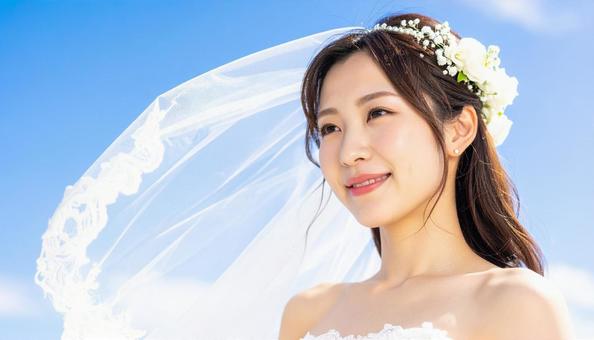 青空にベールがなびくウエディング姿の花嫁 青空にベールがなびくウエディング姿の花嫁の写真