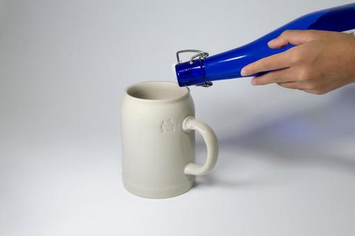 ビールジョッキに青い瓶から注ぐ様子 注ぐ,ジョッキ,瓶の写真素材