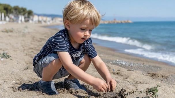 波打ち際で砂遊びをする子ども 波打ち際で砂遊びをする子どもの写真