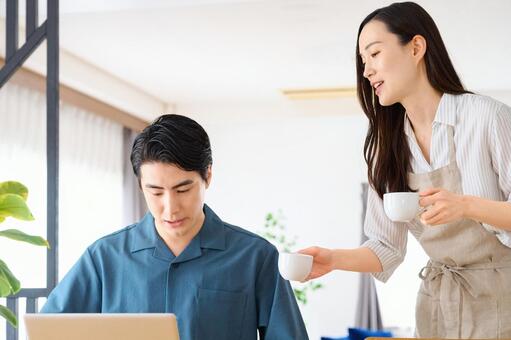 在宅ワークの夫にコーヒーを差し入れる妻 夫婦,コーヒー,差し入れの写真素材