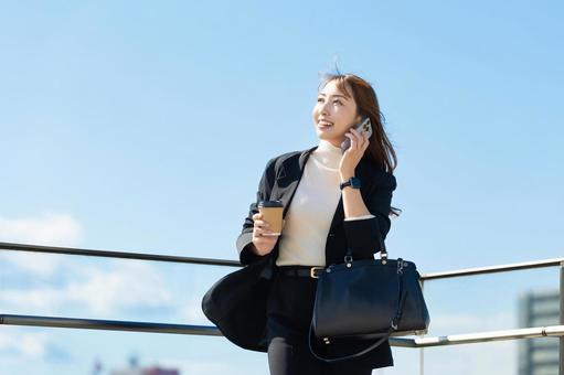 スマホで話す笑顔の女性・ビジネスウーマン 女性,スマホ,スマートフォンの写真素材