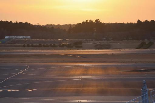 オレンジ色の夕空と滑走路の空港の風景 オレンジ色,夕空,滑走路の写真素材