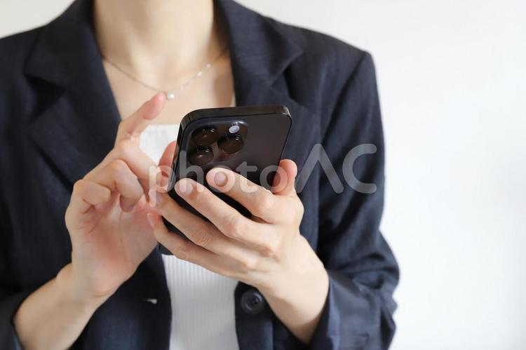 スマートフォンを使うビジネスウーマン スマートフォン,スマホ,女性の手の写真素材