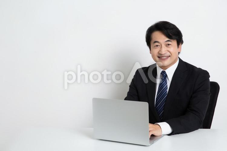 笑顔で仕事をしている中年のサラリーマン男性（コピースペース） 中年,上司,会社員の写真素材