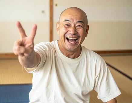 ピースを差し出す笑顔の男性 ピースを差し出す笑顔の男性の写真