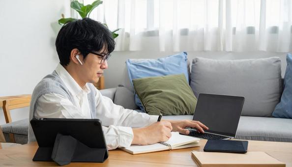 自宅のリビングで英会話の勉強をする男性の写真