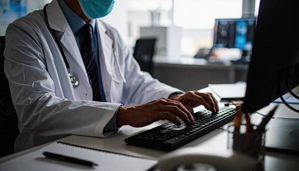 病院で電子カルテに入力する男性の手もと 病院で電子カルテに入力する男性の手もとの写真