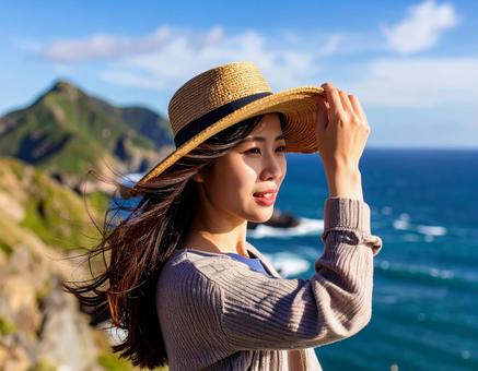 海風に吹かれながら遠くを見つめる女性 海風に吹かれながら遠くを見つめる女性の写真