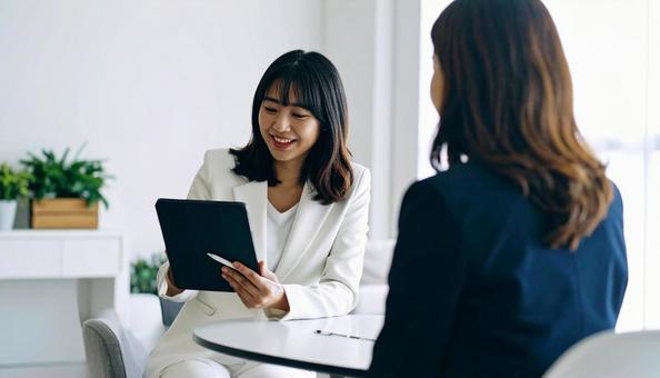 タブレットを使って説明する女性営業マン タブレットを使って説明する女性営業マンの写真