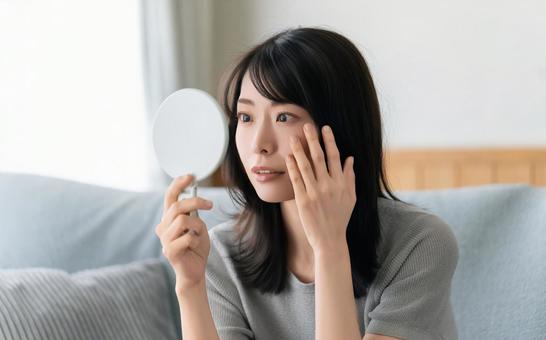 鏡で肌をチェックする女性 鏡で肌をチェックする女性 女性,美容,健康の写真素材