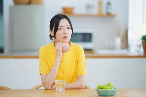 頬杖をするカメラ目線の女性の写真