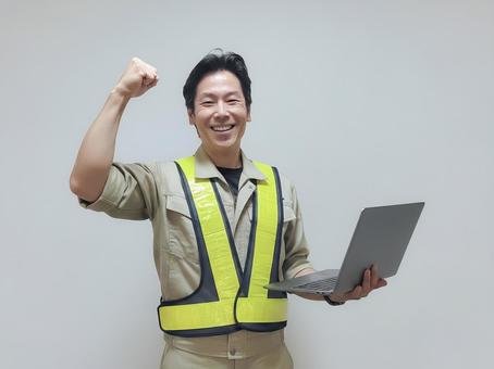 ガッツポーズをする作業服姿の男性 男性,設計,技術者の写真素材