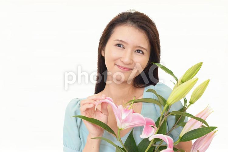 ユリの花を持って微笑む女性 女性,ユリ,百合の写真素材