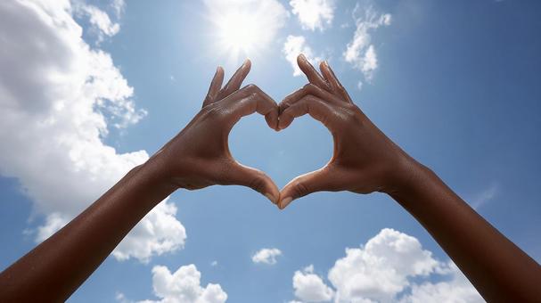 青空と雲に映えるハートの手 青空と雲に映えるハートの手の写真
