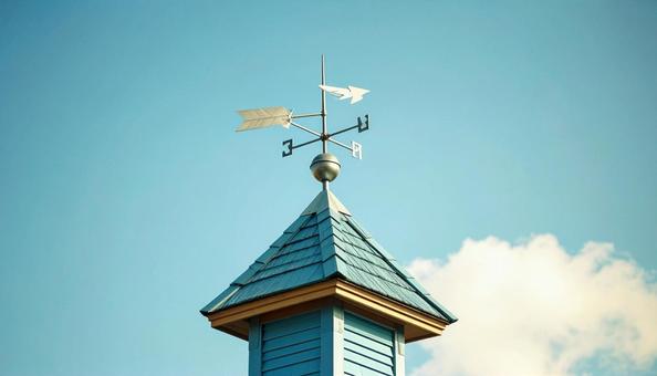 青空と風見鶏が立つ屋根の写真