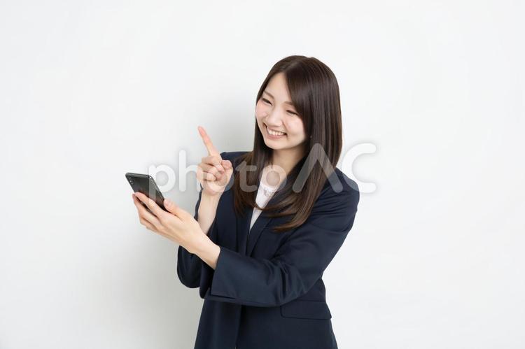 スマートフォンで検索しているものを見つけたビジネスウーマン ビジネス,女性,スーツの写真素材