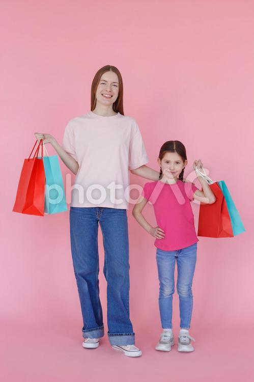 紙袋を持ってカメラ目線の親子（笑顔） 女性,女の子,親子の写真素材