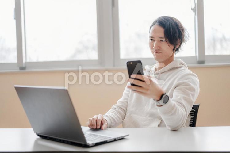 スマホとPCと男性 男性,日本人,若者の写真素材