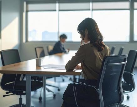 会議室で書類を見てる女性会社員の写真