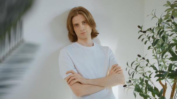 壁にもたれて腕組みをしている白いTシャツを着た男性 男性,外国人,欧米人の写真素材