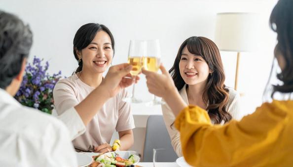 ホームパーティーで乾杯する若い女性 ホームパーティーで乾杯する若い女性の写真