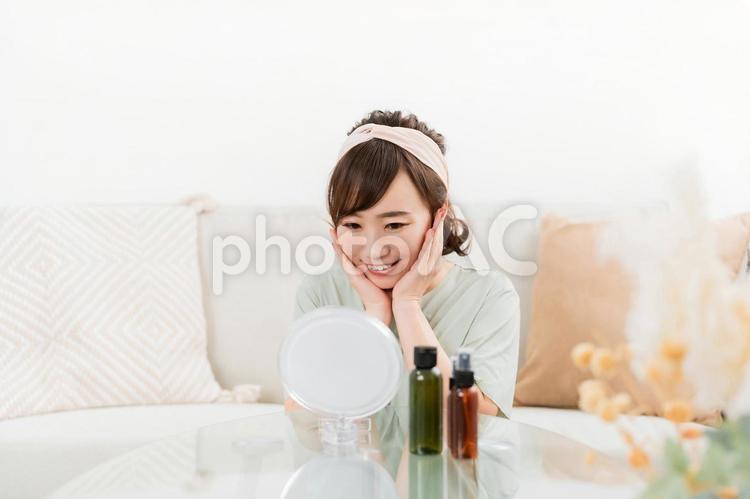 鏡を見ながら基礎化粧品を使う日本人女性 基礎化粧品,コスメ,ヒアルロン酸の写真素材