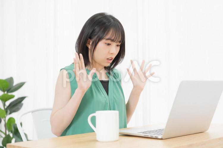 PCを使いながら驚いている若い女性 パソコン,驚く,ビックリの写真素材