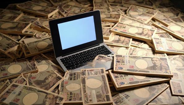 旧一万円札に埋もれるノートパソコン 旧一万円札に埋もれるノートパソコンの写真