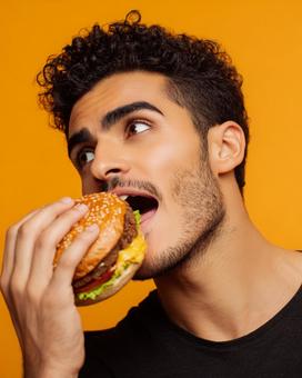 食欲をそそるハンバーガーと若者の表情 食欲をそそるハンバーガーと若者の表情の写真