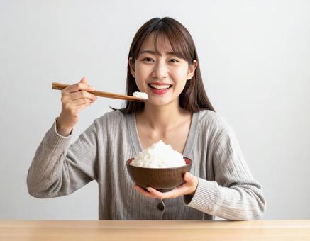 山盛りのごはん茶碗を持つ女性の写真