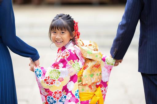 両親と手をつなぎ笑顔を見せる着物姿の女の子 両親と手をつなぎ笑顔を見せる着物姿の女の子 七五三,お参り,七五三参りの写真素材