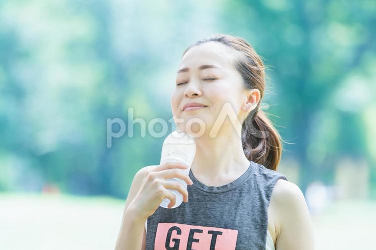 公園で運動（ヨガ）中に水分を補給する女性 水分補給,ダイエット,水の写真素材