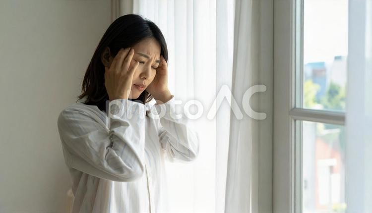 起床時に寝不足と疲労と体調不良の女性 偏頭痛,風邪,倦怠感の写真素材