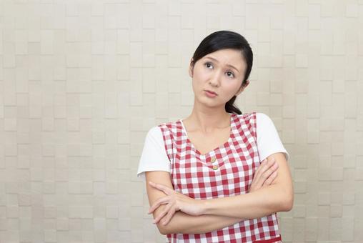 腕組みをして考えるエプロン姿の女性 腕組みをして考えるエプロン姿の女性 女性,考える,疑問の写真素材