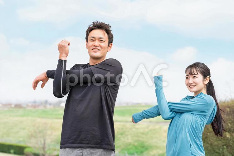 公園で準備運動・腕のストレッチをする男女 ストレッチ,腕,準備運動の写真素材