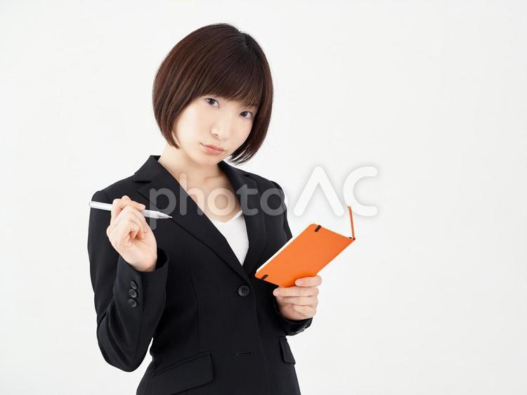 白い背景でメモをとる女性OL 女性,ol,ポーズの写真素材