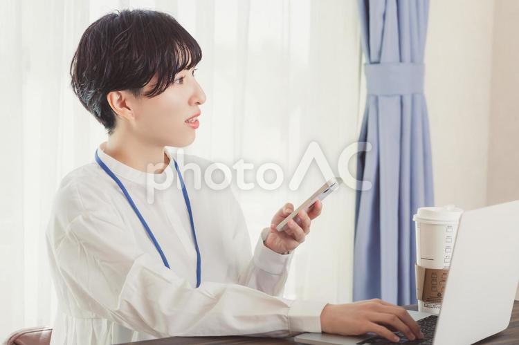 スマホとPCを使う　business ビジネスウーマン,デスクワーク,スマホの写真素材