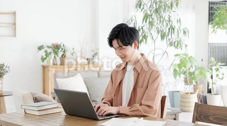 自宅でノートパソコンを使う男性 ノートパソコン,男性,フリーランスの写真素材