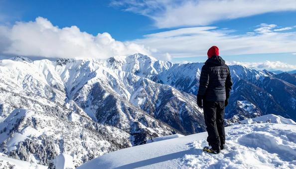 雪山を眺める山登りする男性の写真