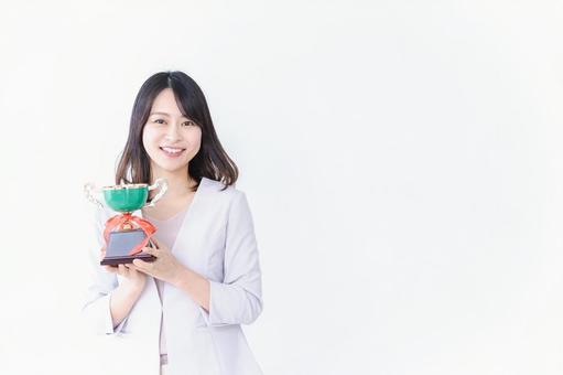会社で表彰される若い女性 会社で表彰される若い女性の写真
