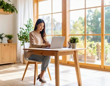 リモートワーク女性 明るいホームオフィスの写真