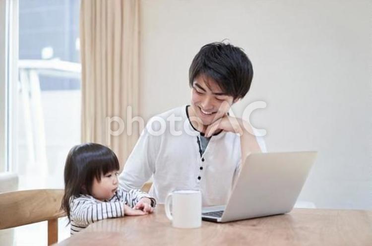 テレワークをしながら子守をするお父さん テレワーク,子守り,子育ての写真素材