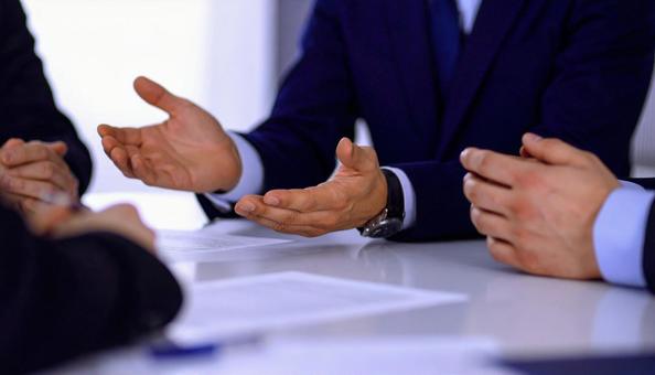 身振り手振りで意見を発表するビジネスマンの写真