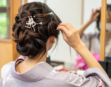 髪をセットする女性の後ろ姿 髪をセットする女性の後ろ姿の写真