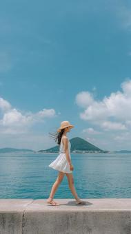 穏やかな海を背景に佇む女性 穏やかな海を背景に佇む女性の写真