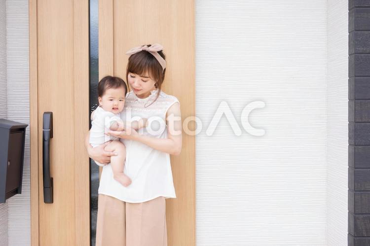 マイホームの前で赤ちゃんを抱く若い女性 親子,家族,赤ちゃんの写真素材