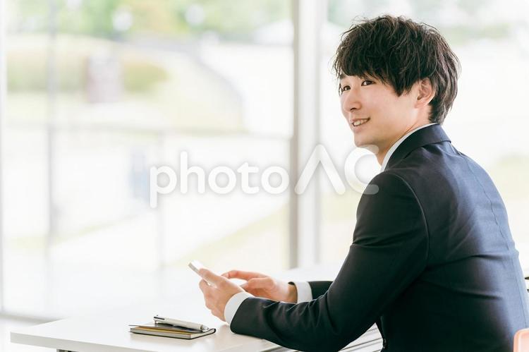 オフィスでスマホを見るビジネスマン スマホ,アプリ,ビジネスマンの写真素材