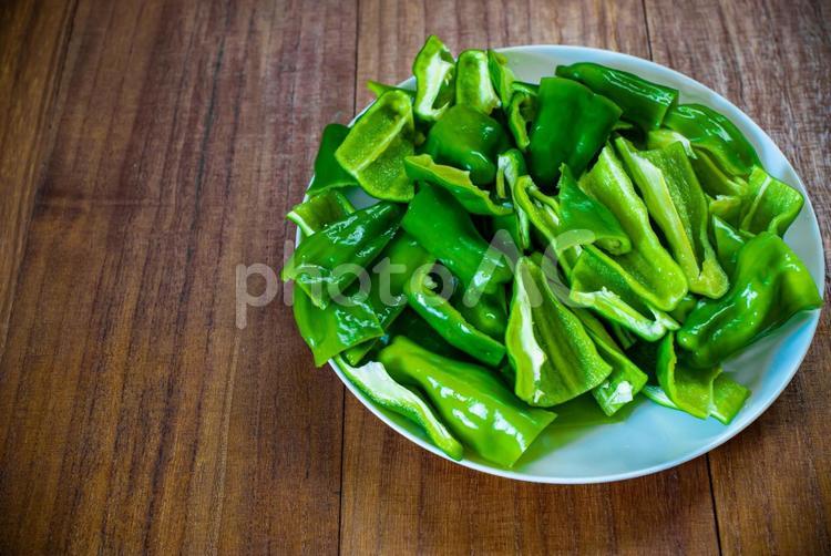 皿に乗せたピーマン、木目テーブルの背景 野菜,食べ物,ピーマンの写真素材