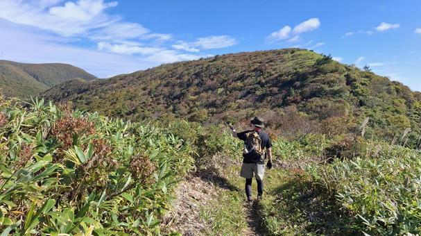 紅葉の登山道で景色を指さす登山者 紅葉の登山道で景色を指さす登山者の写真
