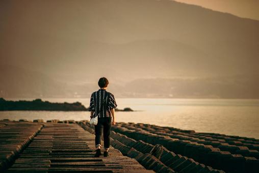 <素材>孤独に夕暮れの海を散歩する女性 <素材>孤独に夕暮れの海を散歩する女性 女性,海,散歩の写真素材